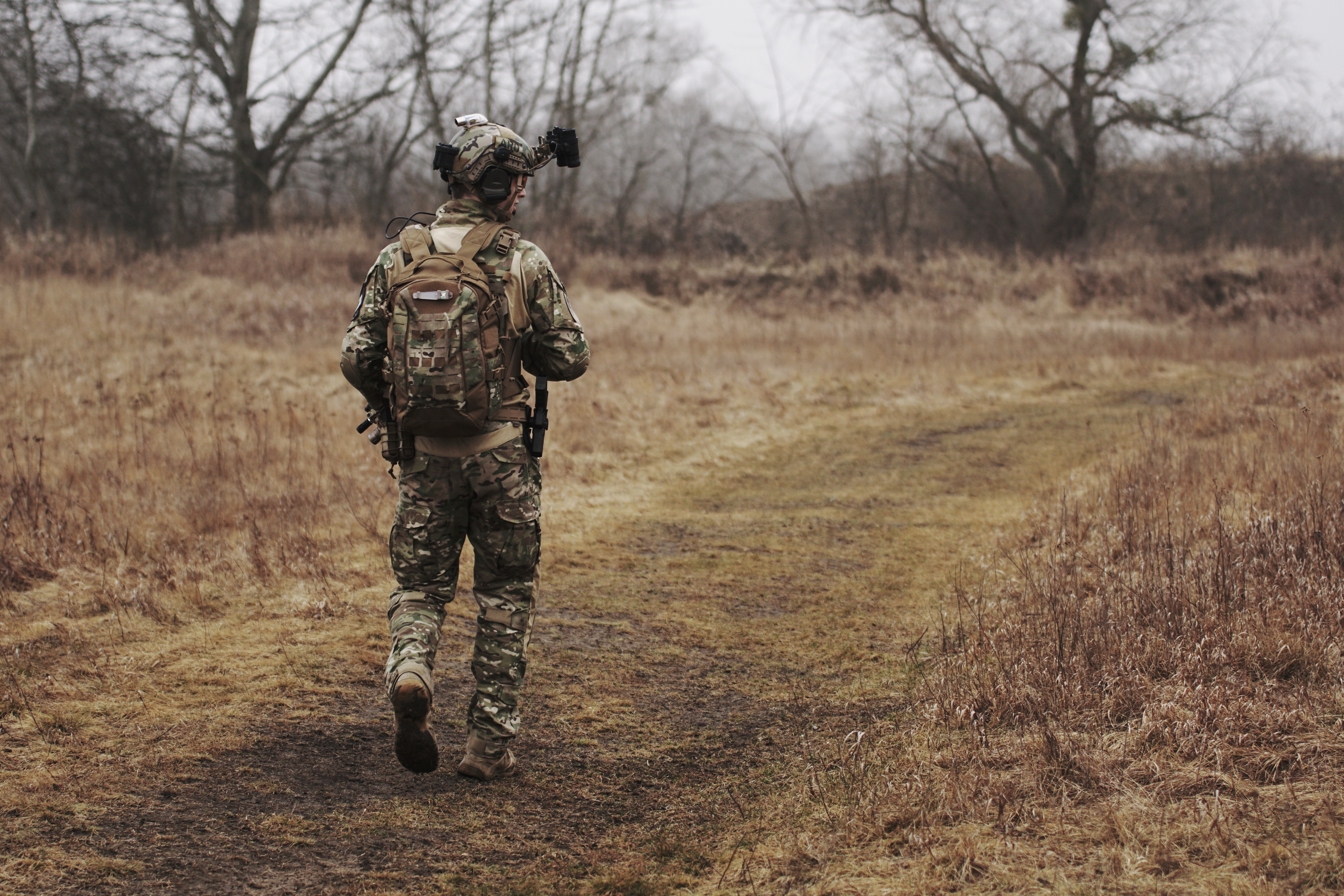 military soldier walking alone through a field